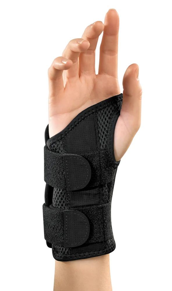 The Mueller Green Fitted Wrist Brace, a black contoured wrist brace, shown on a hand against a white background